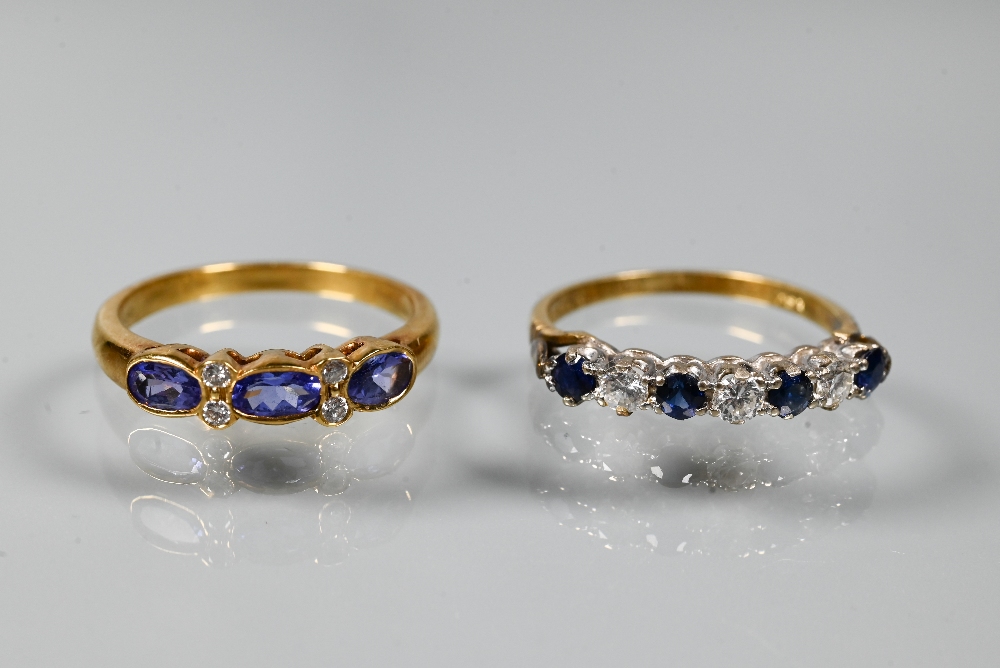 An 18ct yellow gold ring set with three oval blue sapphires with two diamonds between, size P to/w a