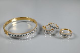 A diamond and blue topaz suite comprising half-hinged bangle with alternate channel-set diamonds and