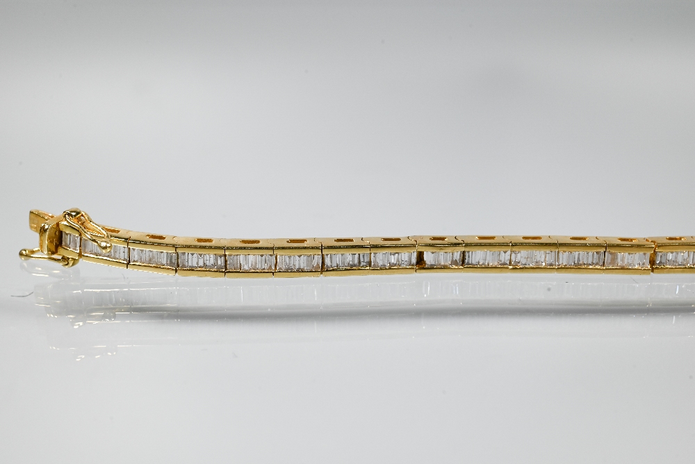 A modern diamond bracelet, the baguette-cut diamonds channel set in 18ct yellow gold, with concealed - Image 3 of 5