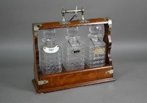 An old silver plate mounted oak three bottle tantalus, 36 cm x 13 cm x 35 cm h (with key)