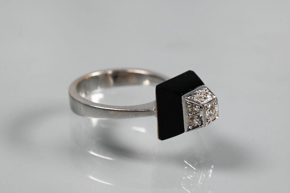 An Art Deco style diamond and onyx ring of geometric form, unmarked white metal set, size K 1/2