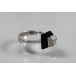 An Art Deco style diamond and onyx ring of geometric form, unmarked white metal set, size K 1/2