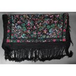 A Chinese black silk fringed piano shawl, abundantly embroidered with Pagoda scenes, figures and