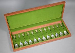 A teak-cased set of twelve Royal Horticultural society Flower Spoons, the finials with inset gilt