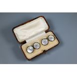 A cased pair of 18ct yellow gold chain-linked cufflinks set mother of pearl with enamel border and