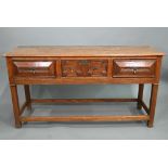 An 18th century style three drawer low dresser, the centre drawer with applied geometric