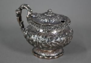 A good George IV silver mustard with hinged cover, scroll handle and stemmed foot, richly embossed
