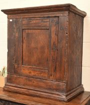 A small 18th century oak cupboard with single panelled door, 64 x 40 x 70 cm high