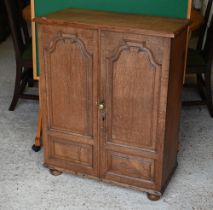 An old oak twin arched panelled door cupboard, 73 cm x 38 cm x 91 cm h