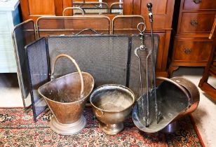 An antique copper coal scuttle to/with a brass coal bucket, a brass planter, two (differing) fire