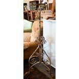 An antique painted wrought iron adjustable standard lamp