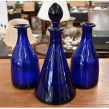 A 19th century pair of Nailsea-type blue glass mallet decanters to/w a conical decanter with stopper