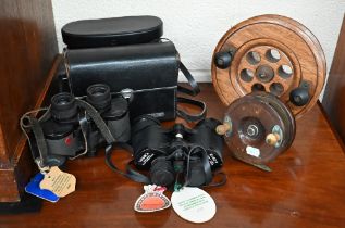 An antique 4 1/2" turned wood fishing reel by A W Gamage Ltd (Holbror) to/w an 8" centre-pin reel