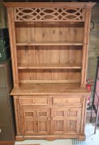 A waxed pine dresser with plate rack on a base with two drawers and quad-panelled doors, 118 cm wide