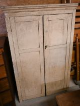 An old distressed cream painted pine cupboard, the two doors enclosing fitted shelves, 106 cm x 42