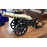 WITHDRAWN A brass model cannon on cast iron stand, 46 cm long