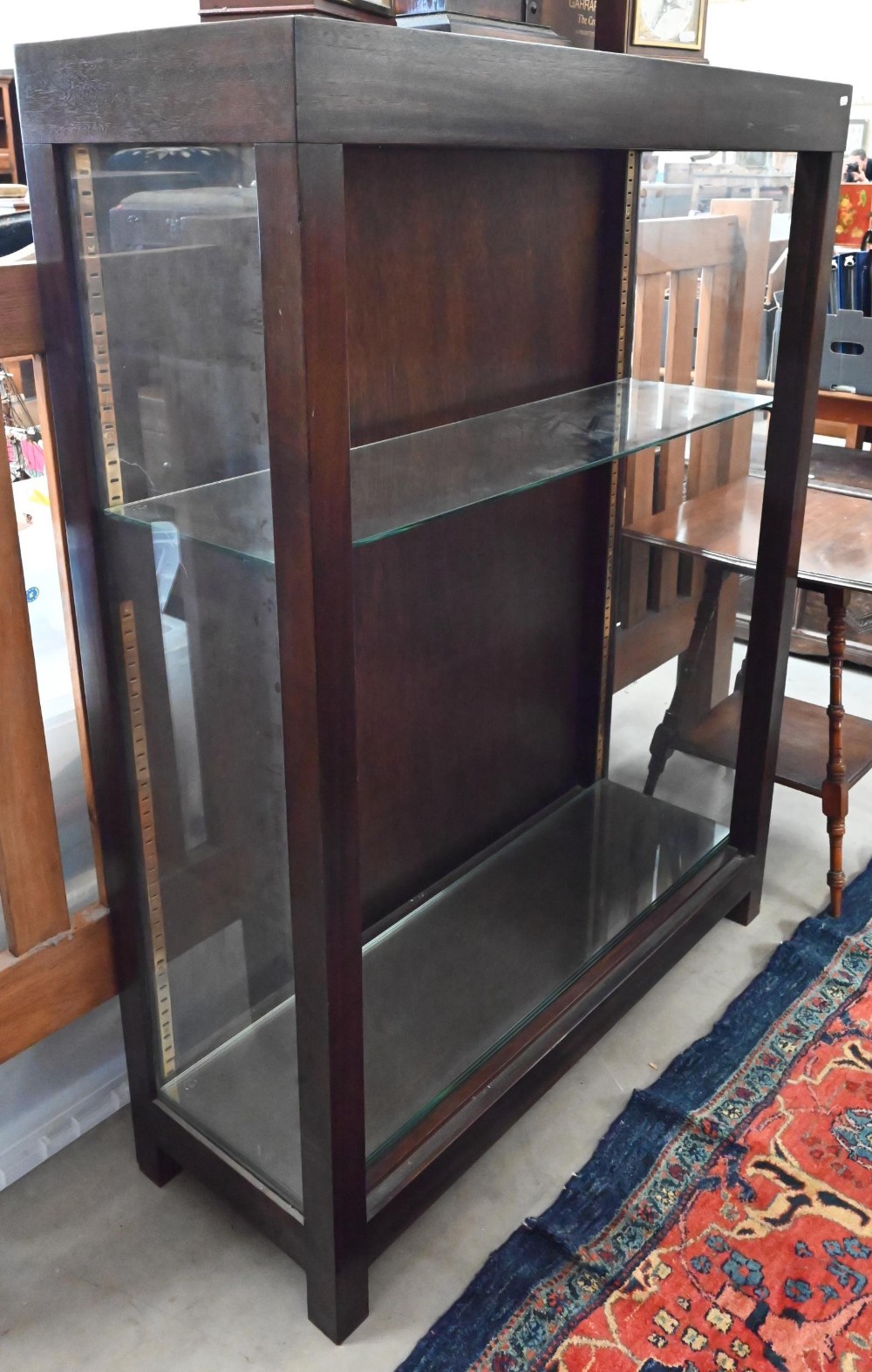 A stained hardwood display cabinet with glazed side panels and four glass shelves (3 lacking