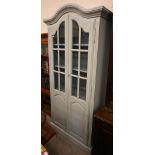 A distress-grey painted French dresser with part-glazed and arch panelled doors enclosing shelves