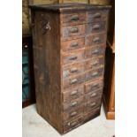 An antique stained pine twenty drawer chest, ex shop fitting, with cast metal fittings (one