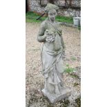 A weathered cast stone garden statue of a classical maiden
