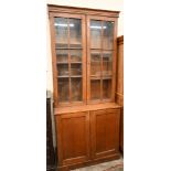 An early 20th century oak cabinet bookcase, the top section with glazed doors enclosing adjustable