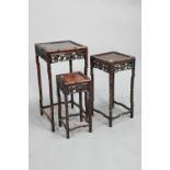 A nest of four antique Chinese rosewood tables, with carved and pierced side panels - the largest