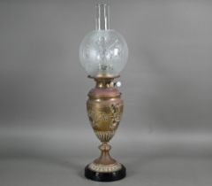 A copper and brass oil lamp with etched glass shade