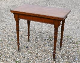 A late Victorian mahogany card table with baize-lined folding top and turned supports with brass