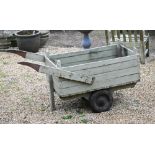 An old wood planked garden hand truck on twin wheel single axle