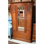 An Art Nouveau satin walnut wardrobe, the triple front centred by a mirrored door over a full