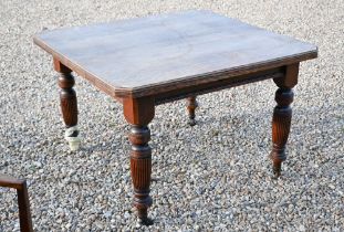 An oak dining table of square proportions, previously a wind action extending table, now fixed at