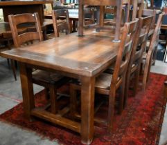 A rustic oak dining table with cleated rectangular top on square supports united by stretchers,