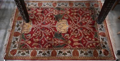 A red ground Agra rug, floral and foliate design on red ground with turquoise border, 186 x 124 cm