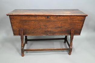 An antique oak dough bin, oak and walnut, the tapered body with single plank top, raised on part