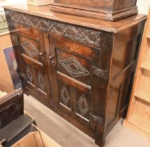 An antique carved oak cupboard with panelled doors (a/f), 135 x 55 x 115 cm high
