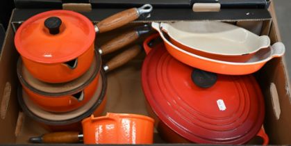 A graduated set of three Le Creuset Flame lipped saucepans with lids, to/w two matching graduated