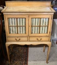 A vintage Italian painted cabinet, with glazed doors over two drawers and raised on cabriole