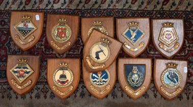 Ten Royal Naval ship's badges on oak shields, to/w a Royal Marines Badge