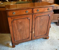 A two door mahogany cabinet, with pair of frieze drawers over twin beaded panel doors, on shaped