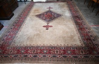 A large Turkish Isparta camel ground carpet, with central diamond medallion and red border, 387 x