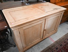 A waxed pine cabinet with panelled cupboard doors, 128 cm wide x 60 cm deep x 78 cm high
