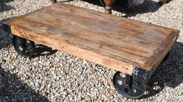 An industrial design hardwood and metal mounted factory cart coffee table, 120 cm wide x 70 cm