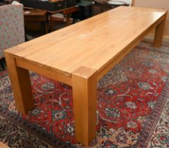 A large contemporary light oak corner-leg dining table, rectangular top with square supports (