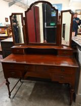 An Edwardian walnut inlaid dressing table, the raised back with levelled triptych mirror, on slender