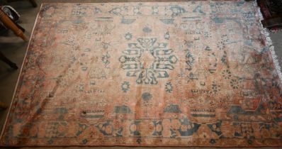 A pink ground Middle Eastern carpet, the stylised floral design with blue border, 242 x 150 cm