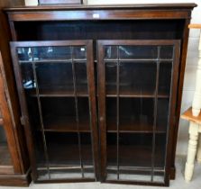 Oak bookcase with glazed doors enclosing three adjustable shelves, 122 cm wide x 34 cm deep x 138 cm