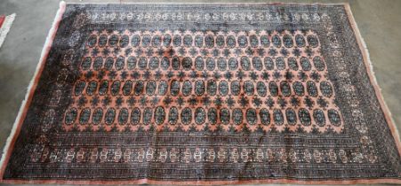 A Pakistani Bokhara rug, the peach ground with repeating gul design, 245 x 152 cm