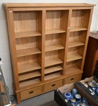 A modern oak open bookcase with adjustable shelves on three drawer base, 186 cm wide x 34 cm deep