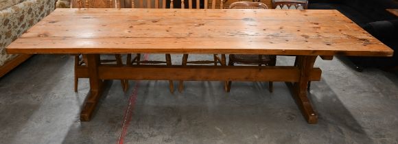 A substantial waxed pine refectory dining table with four-plank rectangular top on twin trestle