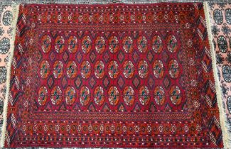 A Teke Turkoman red ground rug with repeating gul design, 101 x 69 cm to/w a smaller Turkoman rug